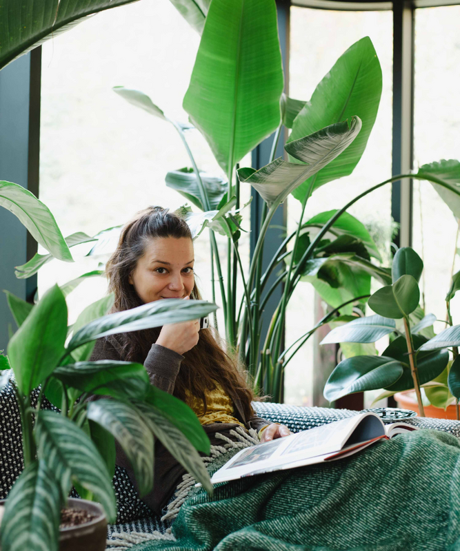 woman reading among houseplants